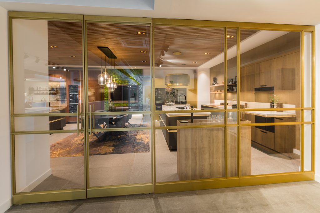 Stalen deur met messing afwerking bij Grando Keukens Zwaag, met glas en moderne, luxe