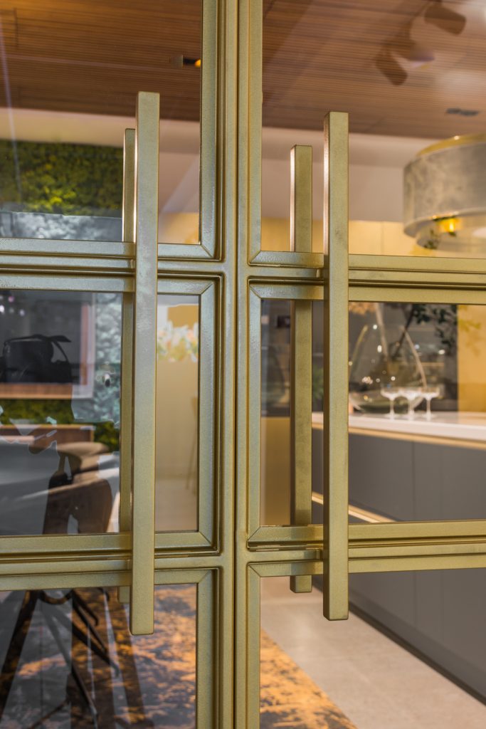 Stalen deur met luxe messing afwerking en glas, met verfijnde lijnen en een moderne, elegante uitstraling.
