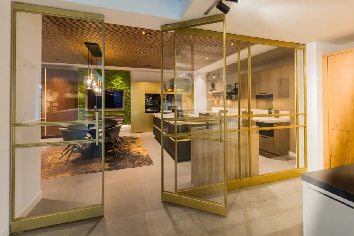 Stalen deur met messing afwerking bij Grando Keukens Zwaag, met glas en moderne, luxe