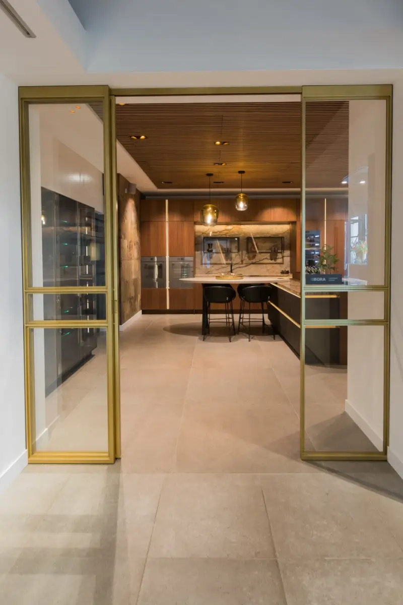 Stalen deur met messing afwerking bij Grando Keukens Zwaag, met glas en moderne, luxe uitstraling.