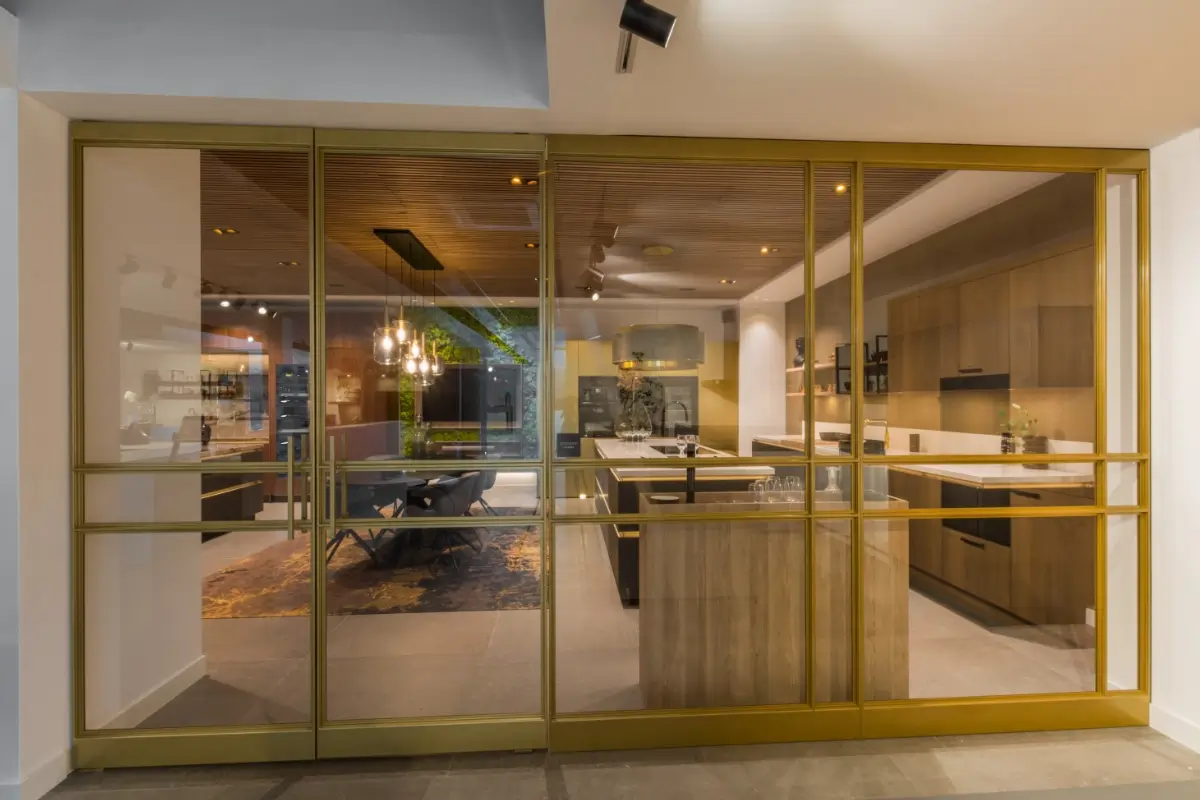 Grando keukens Stalen deur met messing afwerking bij Grando Keukens Zwaag, met glas en moderne, luxe