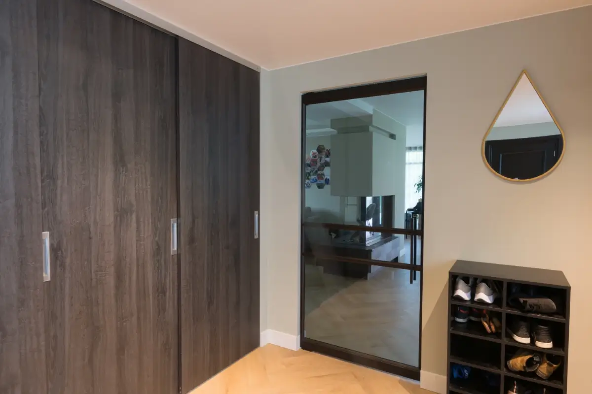 Taatsdeur en raampaneel in modern interieur. Deze deur is uitgevoerd in RAL 8022 in combinatie met grijs glas