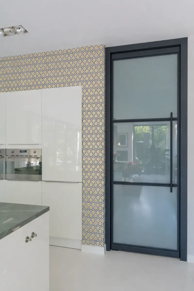 Taatsdeur met melkglas als scheiding tussen keuken en wasruimte.