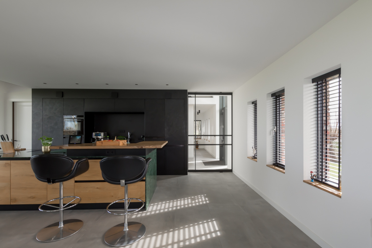 Industrieel interieur met stalen taatsdeur met doorlopende duw- trekstang.