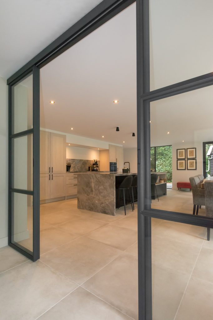 Stalen pui met schuifdeuren in modern interieur.