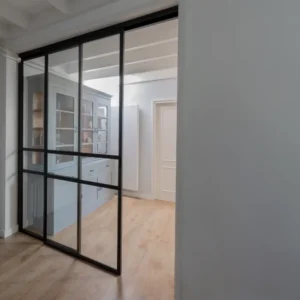 Stalen schuifdeur met raampaneel in landelijk modern interieur.
