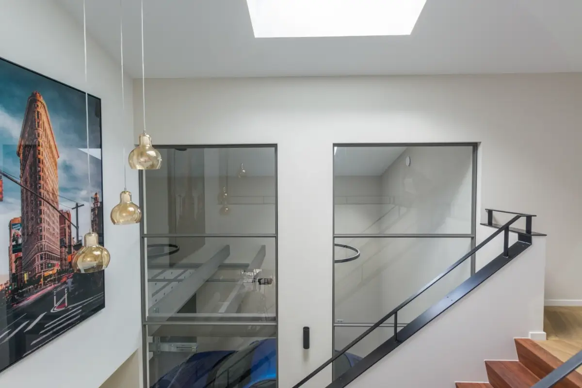 Raampanelen als roomdivider tussen woonkamer en garage.