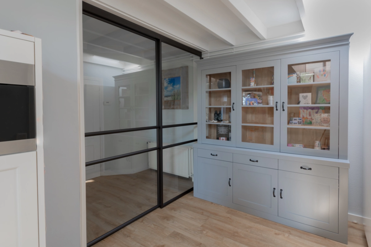 Stalen schuifdeur met raampaneel in landelijk modern interieur.