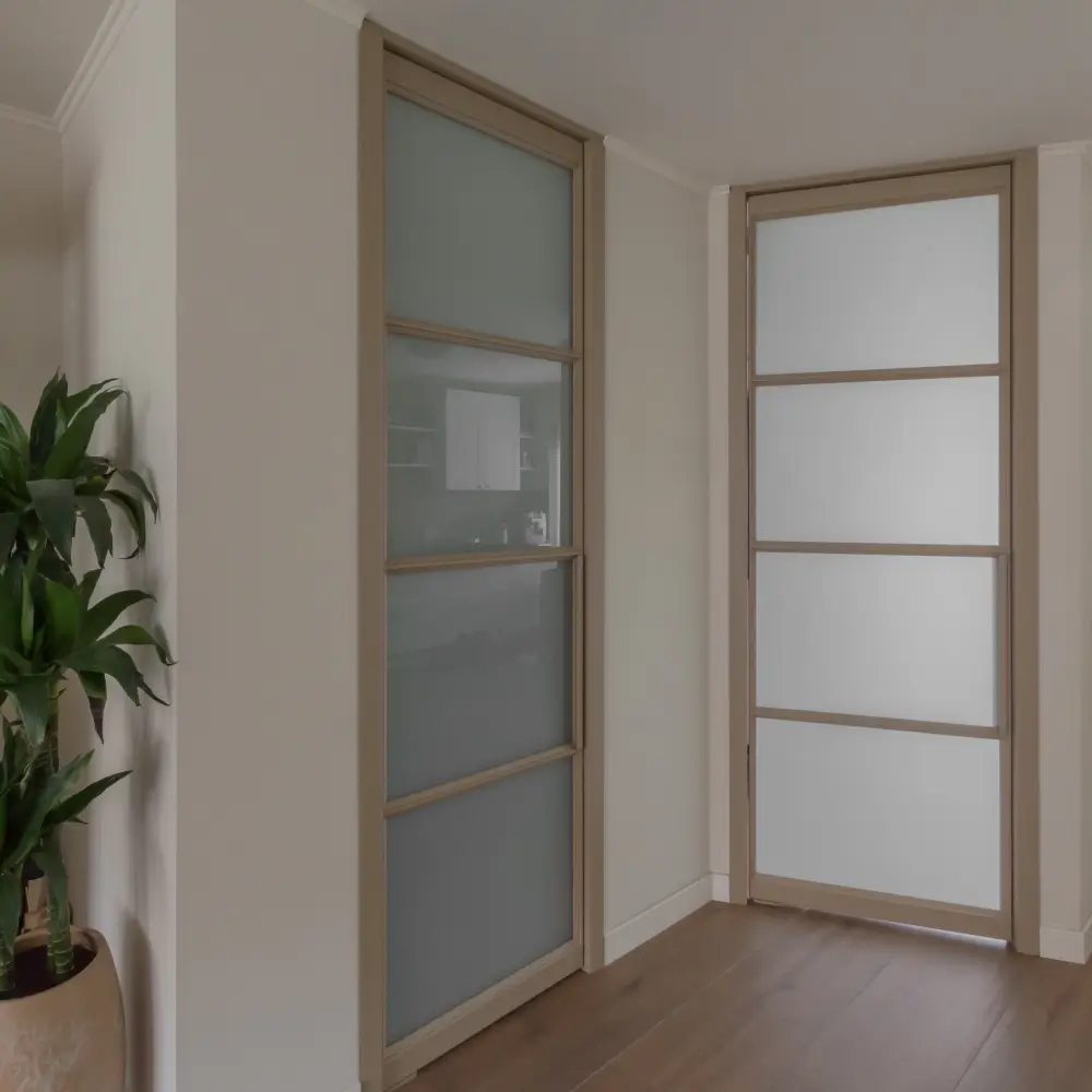 Woonkamer met vernieuwd stalen kozijn en stalen taatsdeur voor trap.
