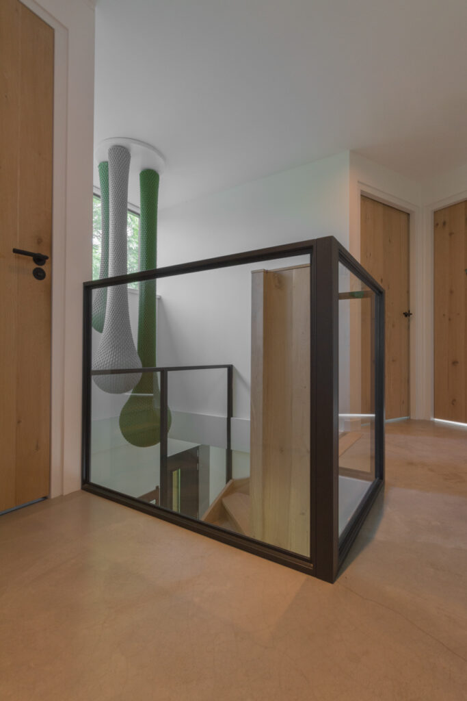 Moderne woning met stalen raampanelen als balustrade bij trap.