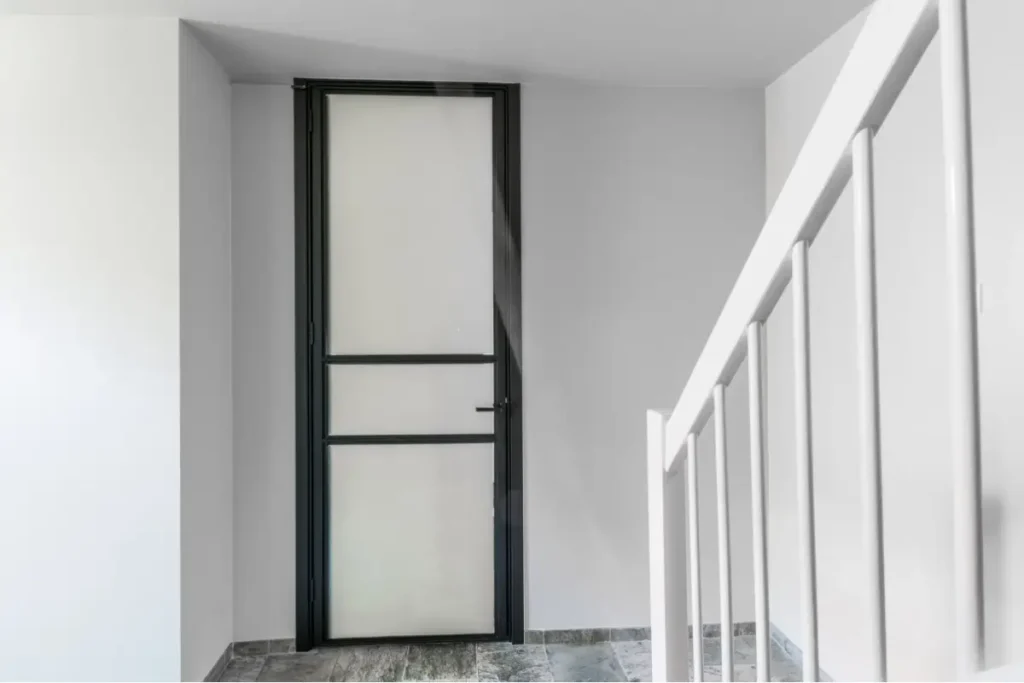 Stalen scharnierdeur met privacy glas uitgevoerd in RAL 9005 gitzwart