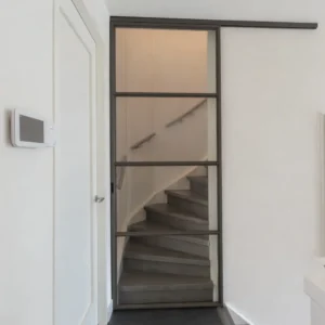 Stalen schuifdeur in splitlevel woning voor trap