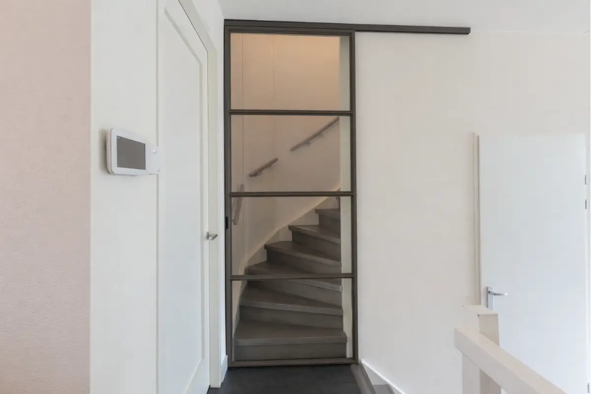 Stalen schuifdeur in splitlevel woning voor trap
