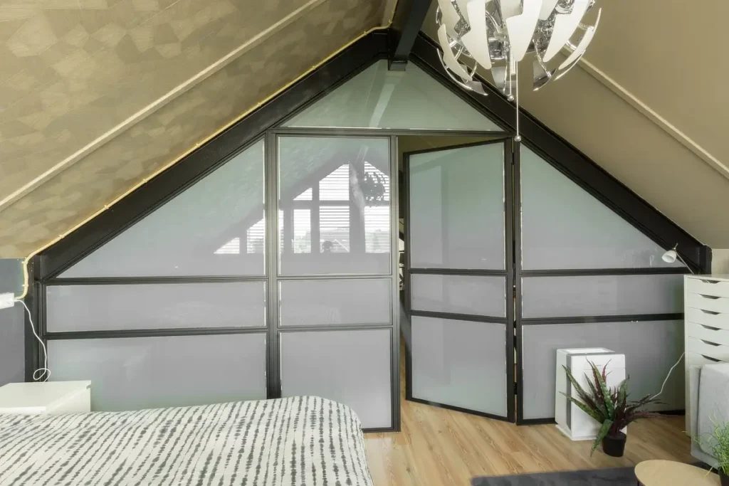 Stalen pui onder schuindak. op zolder slaapkamer met privacy glas.