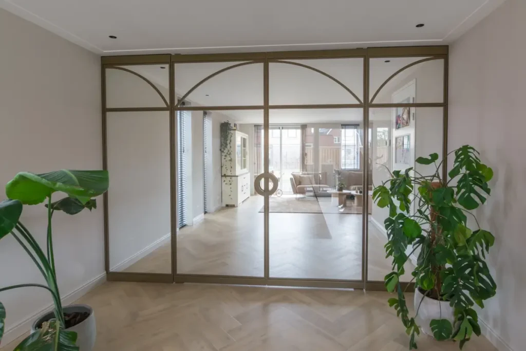 Exclusieve stalen taatsdeuren met boogdetails in een licht beige interieur.