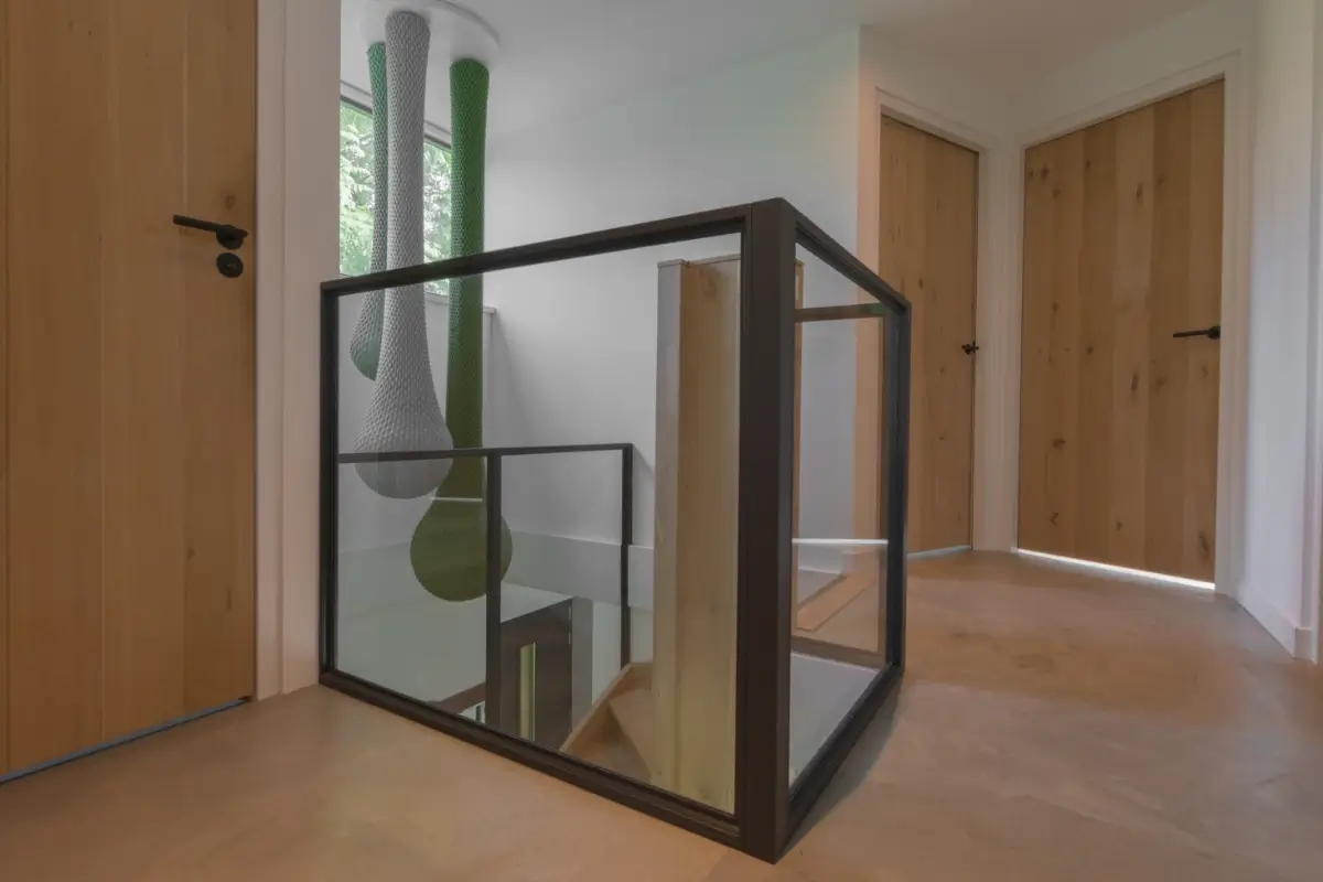 Moderne woning met stalen raampanelen als balustrade bij trap.